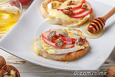 Bruschetta sandwiches with brie or Camembert cheese, apples, walnuts and honey Stock Photo