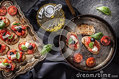 Bruschetta toast with mozzarella tomatoes olives and basil. Stock Photo