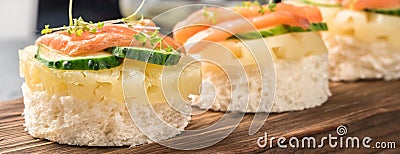 Bruschetta toast of white bread with slices of pineapple cucumber fish salmon fresh green sprouts Stock Photo