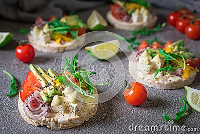 Bruschetta with tomato, avocado, herbs and arugula. Rustic background. Top view Stock Photo