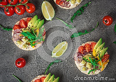 Bruschetta with tomato, avocado, herbs and arugula. Rustic background. Top view Stock Photo