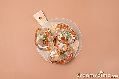 Bruschetta with Tomatoes Cheese and Herbs on Toasted Garlic Cheese Bread on Wooden Tray Orange Background Stock Photo