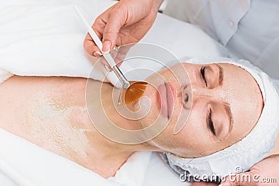 Brush applies an enzyme mask to a woman`s face Stock Photo