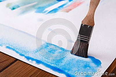 Brush in hands. Artist creating watercolor painting Stock Photo