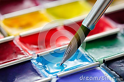 Brush for watercolor painting closeup and set of watercolor paints. Stock Photo