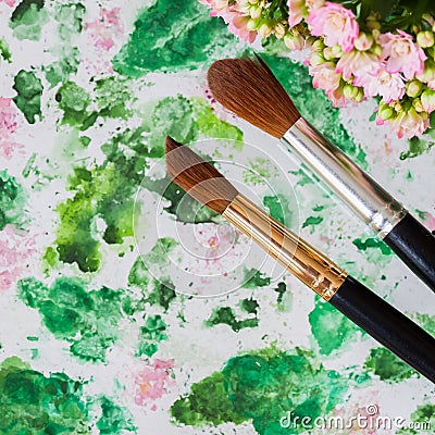 Brushes and hand made watercolor abstract floral background. Romantic concept of spring, lifestyle, hobbies. Top view Stock Photo