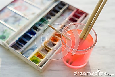 Brushes and professional watercolor paints on wooden white window ledge Stock Photo