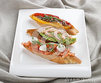 Brushetta snacks for wine. Variety of small sandwiches on a textile background Stock Photo