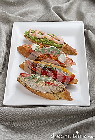 Brushetta snacks for wine. Variety of small sandwiches on a textile background Stock Photo