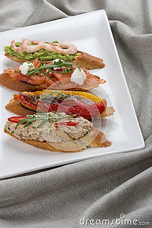 Brushetta snacks for wine. Variety of small sandwiches on a textile background Stock Photo