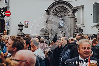 View of Manneken pis fountain sculpture in central Brussels over the crowd of people Editorial Stock Photo