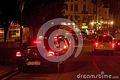 BRUSSELS, BELGIUM - SEPTEMBER 06, 2014: Night view of a black taxi cars parked on roadside. Editorial Stock Photo