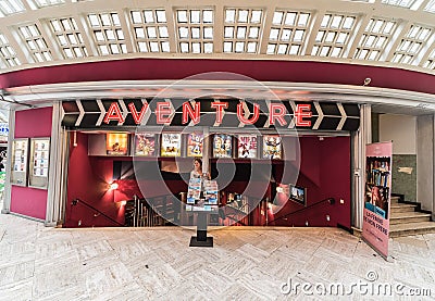 Brussels Old Town, Belgium - Young woman standing in front of the entrance of the Adventure vintage cinema Editorial Stock Photo