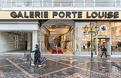 Brussels Old Town, Brussels Capital Region - Belgium - Woman with bicycle and pedestrians walking by the Galerie Porte Louise Editorial Stock Photo