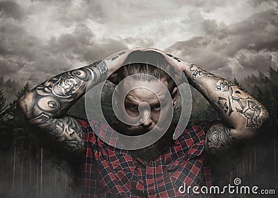 Brutal bearded male with tattooed arm looks down. Stock Photo