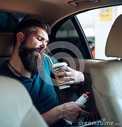 Brutal caucasian hipster with moustache. remote work. coffee time. fast food - hot dog. Mature hipster with beard. Male Stock Photo