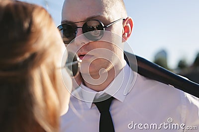 Brutal couple, the bride and groom, wearing black glasses near the car on the road Stock Photo