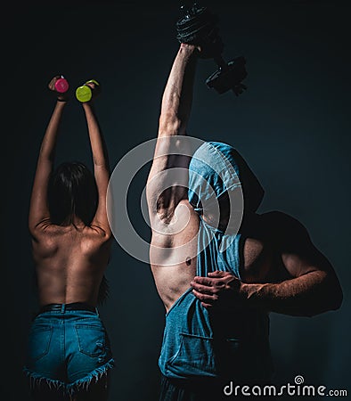 Brutal couple exercising with dumbbells together. Sexy strong fit body. Couple training with dumbbell. Stock Photo