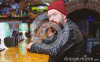 Brutal lonely hipster. Brutal hipster bearded man sit at bar counter. Friday evening. Hipster relaxing at bar. Bar is Stock Photo