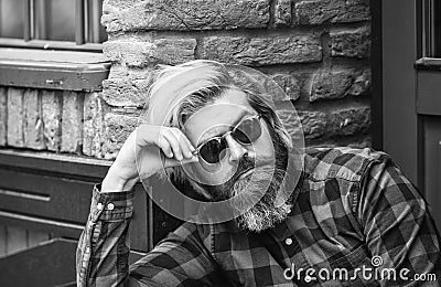 Brutal male with blond hair irish architecture background. Man casual fashion. Hipster in sunglasses. Cool guy. Bearded Stock Photo