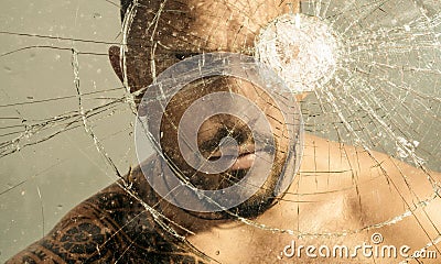 Brutal man, handsome serious male model. Gangster man. Dangerous criminal, hooligan guy on cracked bullet glass. Stock Photo