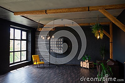 Brutal modern interior in a dark color with a leather sofa and large window. Loft style living room Stock Photo