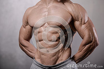 Brutal strong bodybuilder man posing in studio on grey background. Stock Photo