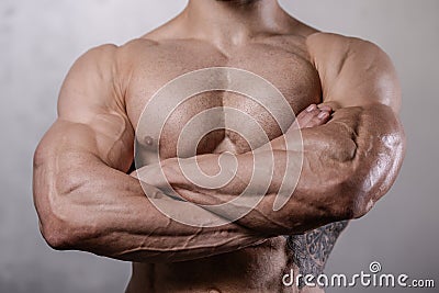 Brutal strong bodybuilder man posing in studio on grey background. Stock Photo