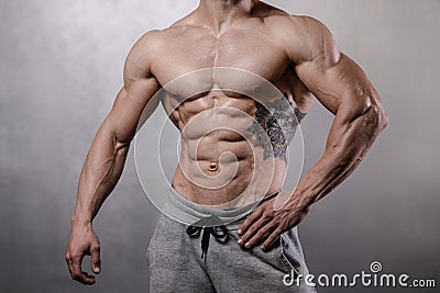 Brutal strong bodybuilder man posing in studio on grey background. Stock Photo