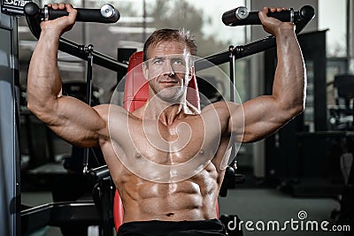 Brutal strong bodybuilder man pumping up muscles and train gym Stock Photo