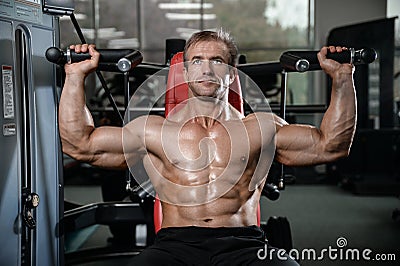 Brutal strong bodybuilder man pumping up muscles and train gym Stock Photo