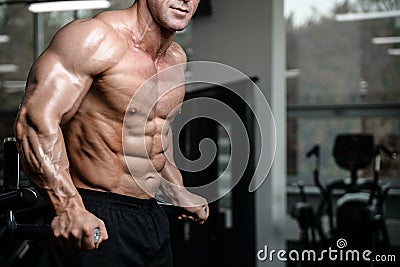 Brutal strong bodybuilder man pumping up muscles and train gym Stock Photo