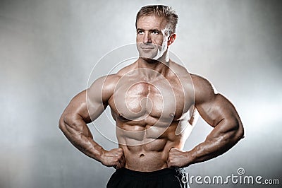 Brutal strong bodybuilder old man posing in studio grey background Stock Photo