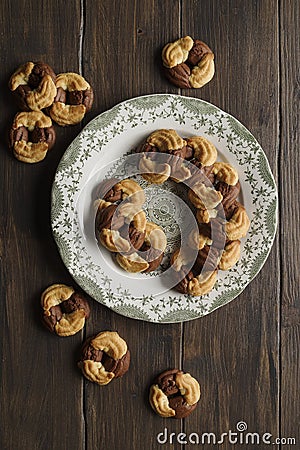 ‘Brutti ma buoni’: homemade rustic biscuits. Some ingredients are: eggs; sugar; flour; butter, and chocolate, on wooden table Stock Photo