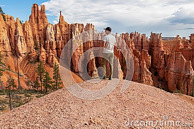 Bryce Canyon - Man with scenic aerial view of hoodoo sandstone rock formations on Queens Garden trail in Utah, USA Stock Photo