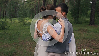 Bräutigam hält Braut auf Armen auf photoshoot im Wald draußen stock video footage Bräutigam hält Braut auf Armen auf photoshoot im Wald draußen stock video footage