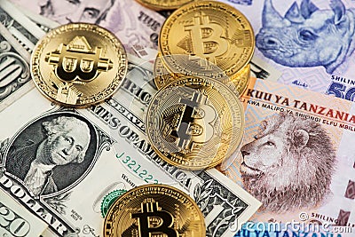 BTC Bitcoin cryptocurrency coins on Tanzania Shilling and US Dollar banknotes close up image. Africa Bitcoin Editorial Stock Photo
