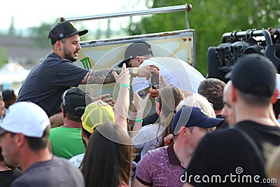 Men giving the crowd free Monster energy drink. Sales promo Editorial Stock Photo