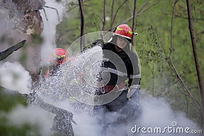 Firefighters using water hoses to extinguish a fire Editorial Stock Photo