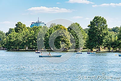 Many people in boats paddling on the lake in King Mihai I park (Herestrau). Couple on a Editorial Stock Photo