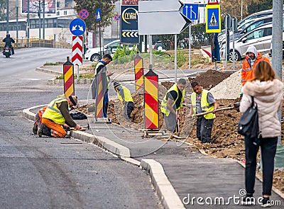 Bucharest/Romania - 11.17.2020: Group of workers with shovels digging a trench along the road in Bucharest Editorial Stock Photo