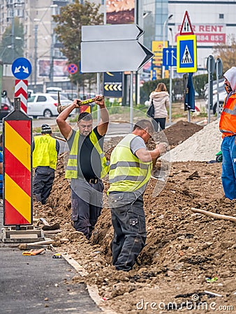 Bucharest/Romania - 11.17.2020: Group of workers with shovels digging a trench along the road in Bucharest Editorial Stock Photo