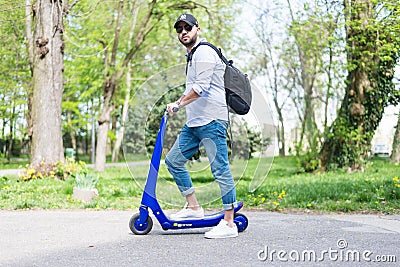Man using blue electric scooter in the park Editorial Stock Photo