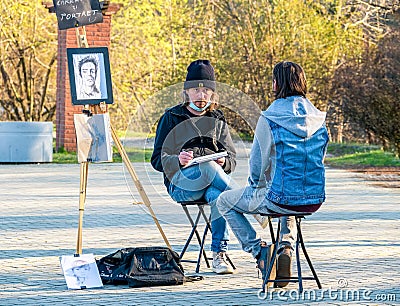 Street artist cartoonist or painter making portraits to people in Herestrau park Kink MIhai I, Editorial Stock Photo