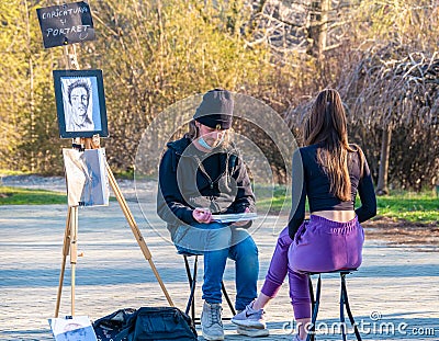 Street artist cartoonist or painter making portraits to people in Herestrau park Kink MIhai I, Editorial Stock Photo