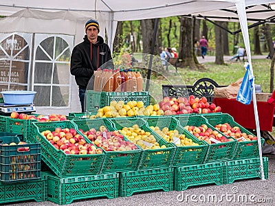Street vendor selling different sorts of apples and fresh apple juice. Stall with fruits for sale Editorial Stock Photo