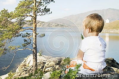 Buchtarma. Child seated on the shores of Inlet. Stock Photo