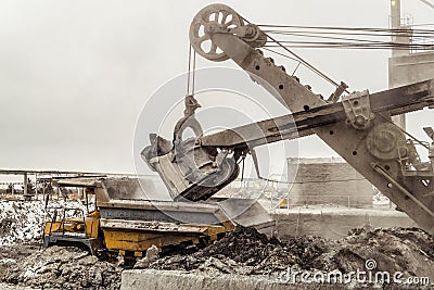 Bucket excavator loads into a large mining dump truck Stock Photo