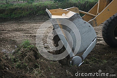 Bucket Loader dumping a load of dirt in road construction Stock Photo