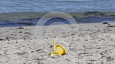 Bucket spade sandcastle Diggers toys on sandy beach with sea wave in UK Stock Photo